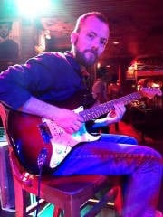 Beard Man Playing A Guitar